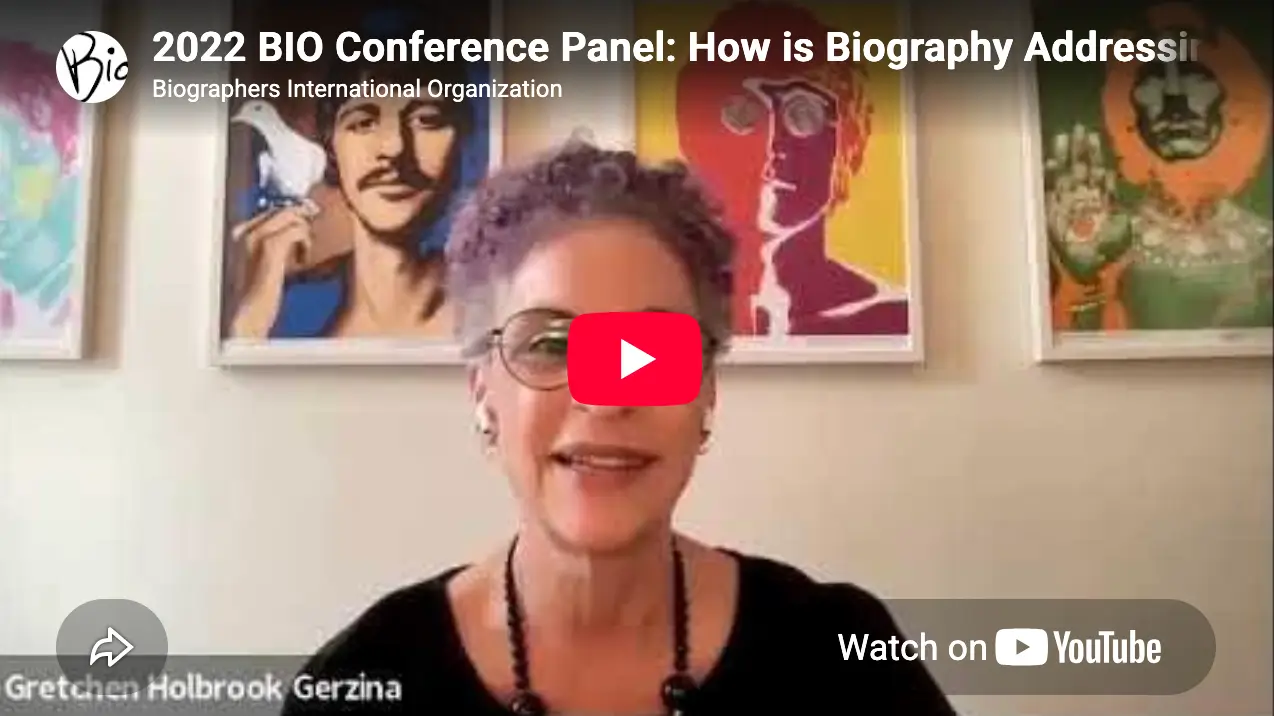 Gretchen Holbrook Gerzina speaks in a video frame labeled "2022 BIO Conference Panel: How is Biography Addressing," with framed pop-art posters behind her.