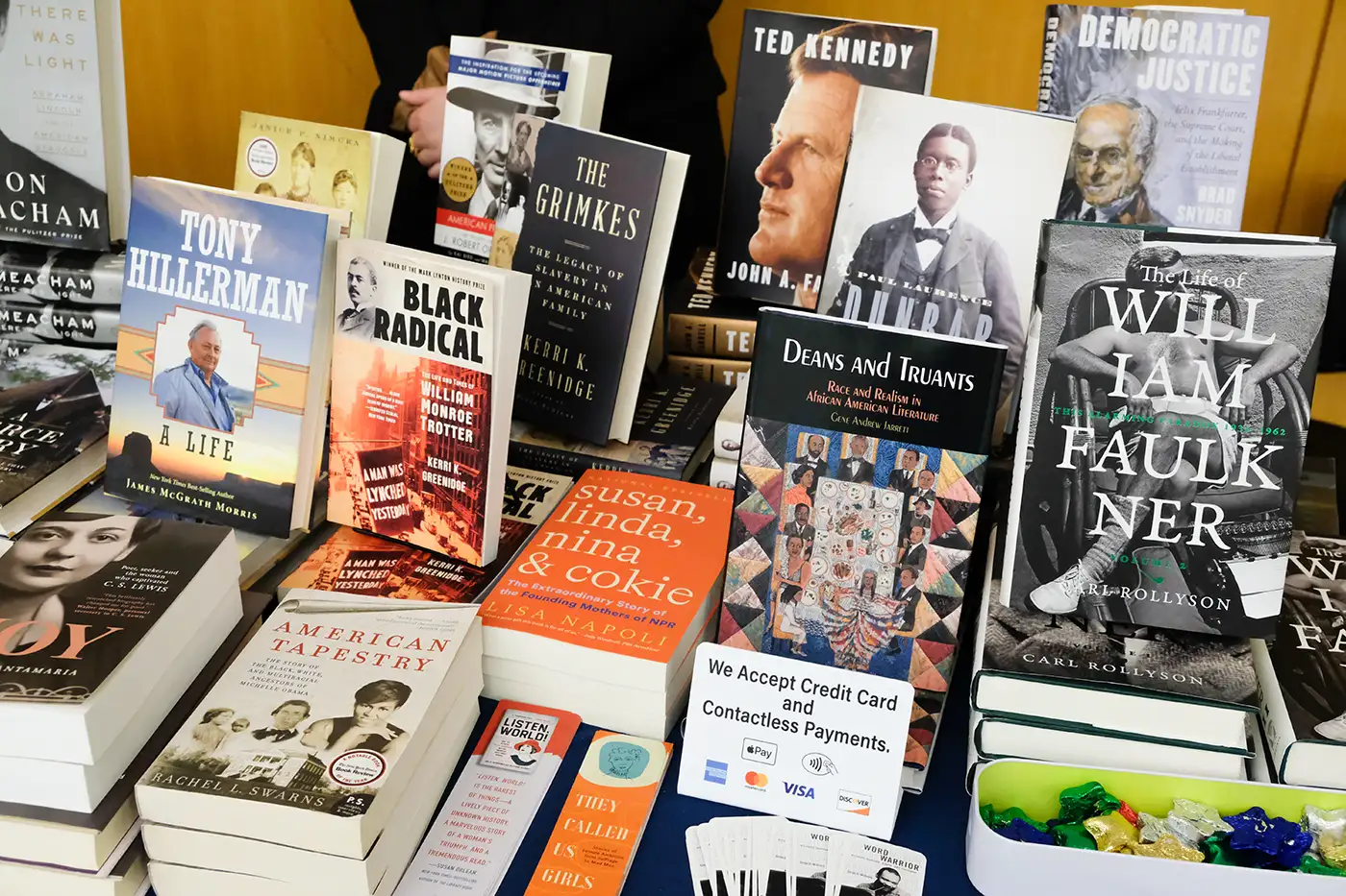 Books piled on a table with some stood up to show the cover